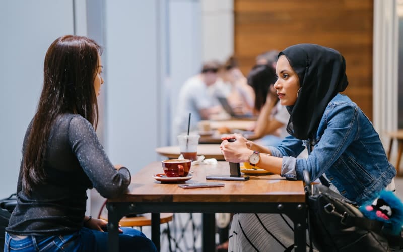 Women sitting at table chatting over a coffee