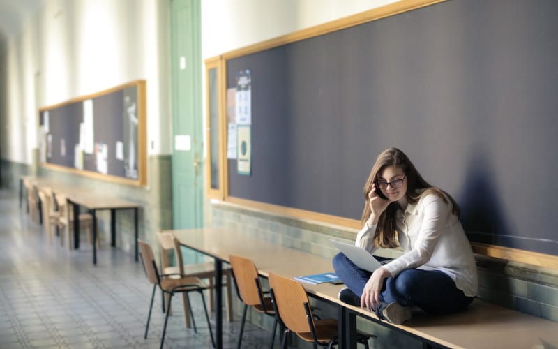 Young woman sitting on a table in a college or school